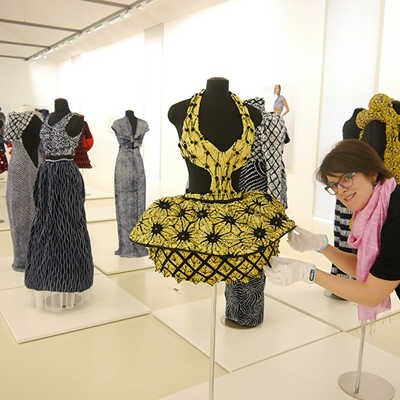 Kuratorin Dorothée Henschel richtet eines der japanischen Kleider in der neuen Shibori-Sonderausstellung. Foto: Stadtmuseum