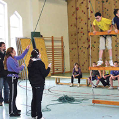 In der Kurfürst-Balduin-Schule besucht Bürgermeisterin Angelika Birk (3. v. l.) unter anderem die Sporthalle. Dort testen am Seil gesicherte Schüler an der schwankenden „Himmelsleiter“ ihre Körperbeherrschung.