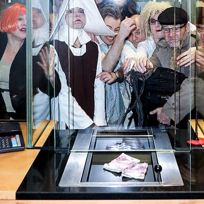 Für ein symbolisches Werbefoto posieren die „Cash“-Darsteller an einem Bankschalter. Foto: Simon Hegenberg