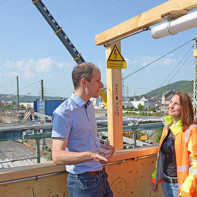 Baudezernent Dr. Thilo Becker (l.) informiert sich im Gespräch mit Sandra Klein (Stabsstelle Stadtumbau Trier-West) und Sebastian Lehnart (StadtRaum Trier) über den Rückbau der alten Eisenbahnüberführung (im Hintergrund).