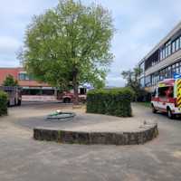 Das Bild zeigt den Schulhof in Ruwer. Rechts ist die Schule zu sehen. Im Hintergrund das Nebengebäude. Drei Feuerwehrautos sind auf dem Schulhof zu sehen. 