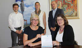Bürgermeisterin Angelika Birk und Dr. Katja Wolf (Transferagentur, vorne, v. r.) präsentieren mit ihren Mitarbeitern Hanno Weigel, Dr. Caroline Thielen-Reffgen sowie Rudolf Fries (hinten, v. l.) den Vertrag