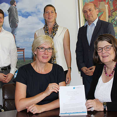 Bürgermeisterin Angelika Birk und Dr. Katja Wolf (Transferagentur, vorne, v. r.) präsentieren mit ihren Mitarbeitern Hanno Weigel, Dr. Caroline Thielen-Reffgen sowie Rudolf Fries (hinten, v. l.) den Vertrag.
