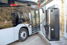 Die Frontpartie eines Stadtbusses ist via Kabel mit einer Ladestation verbunden