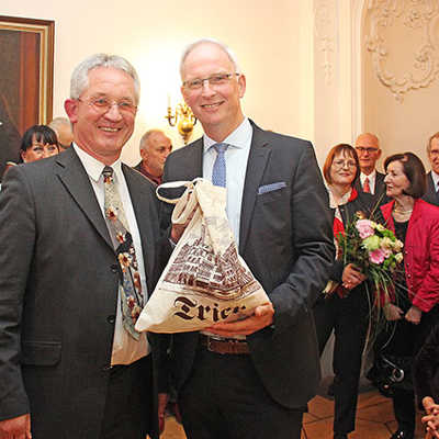 Der alte und der neue Weissebach-Preisträger: Aloys Hülskamp (l.) überreicht Wolfram Leibe eine Tasche mit hilfreichen Gegenständen für dessen verbleibende Amtszeit als Oberbürgermeister.