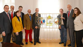 Foto: OB Klaus Jensen und Norbert Kölzer (Firma Binsfeld) präsentieren eines der restaurierten Glaskunstwerke.