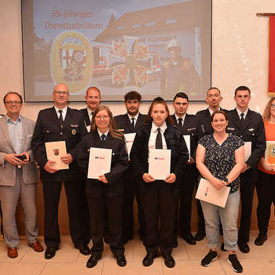 Stefan Wilhelm (stellvertr. Ortsvorsteher), Andreas Kichartz (Leiter Berufsfeuerwehr), Dezernent Ralf Britten und Wehrführer Stephan Kuhn (v. l.) freuen sich mit den beförderten Mitgliedern des Löschzugs Kürenz.