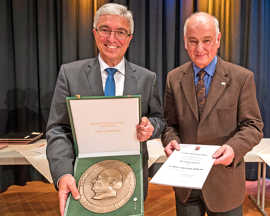 Innenminister Roger Lewentz (l.) präsentiert mit Bernd Michels  die Freiherr-vom-Stein-Plakette, die der Ortsvorsteher für sein kommunalpolitisches Engagement erhalten hat.