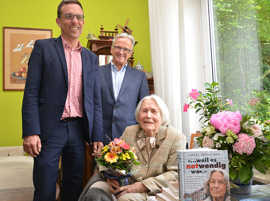 Beigeordneter Thomas Schmitt (l.) und der Heiligkreuzer Ortsvorsteher Theodor Wolber gratulieren Liesel Hünichen zu ihrem 100. Geburtstag.