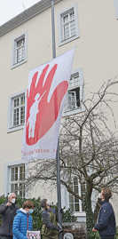 OB Wolfram Leibe hisst die Red-Hand-Flagge zusammen mit Schülern vom FWG, HGT und der IGS.