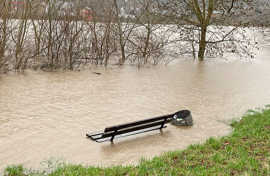 Hiochwasser überspült Bäume und eine Sitzbank am Moselufer