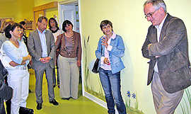 Bildtext: Elisabeth Schuh von „Nestwärme“ (2.v. r.) stellt Monika Thenot (l.) und Berti Adams (CDU-Fraktion) sowie den Beigeordneten Georg Bernarding und Simone Kaes-Torchiani (2. und 4. v.l.) die Krippe vor.