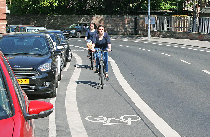 Radfahrstreifen wie hier in der Mustorstraße befinden sich auf der Fahrbahn und sind durch eine durchgehende Linie von den Fahrspuren für den KfZ-Verkehr abgegrenzt.